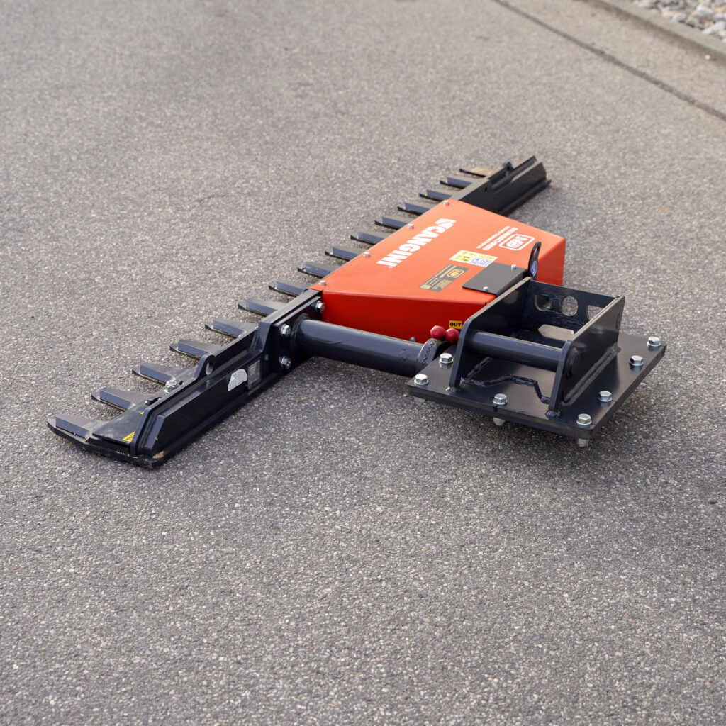 Auf dem Asphalt liegt eine orange-schwarze Astschere mit langen Zinken und schwerem Stahlrahmen, deren Aufnahmen und Schrauben klar sichtbar sind.