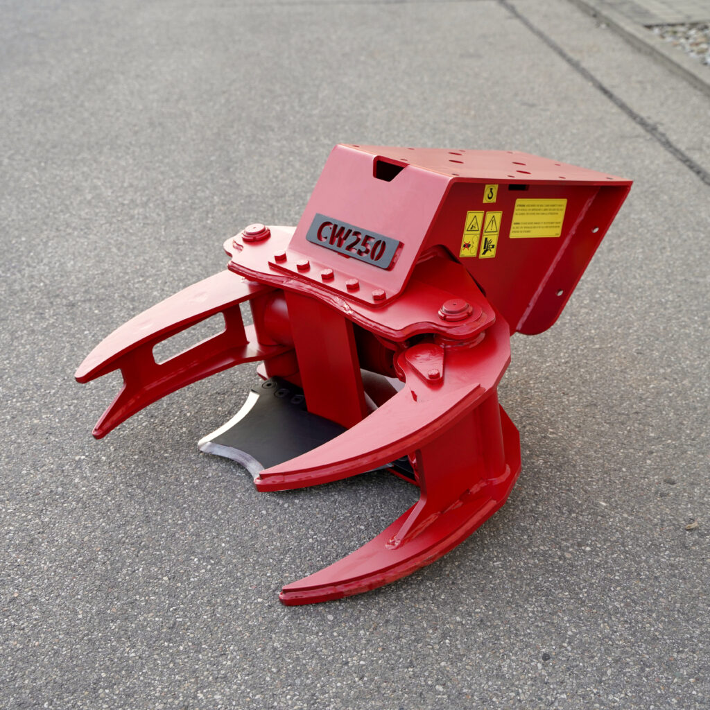 Auf grauem Asphalt steht eine rote Baumschere CW250 mit massiven Greifarmen, Warnaufklebern und sichtbarer Metallkonstruktion vorn im Nahbereich.