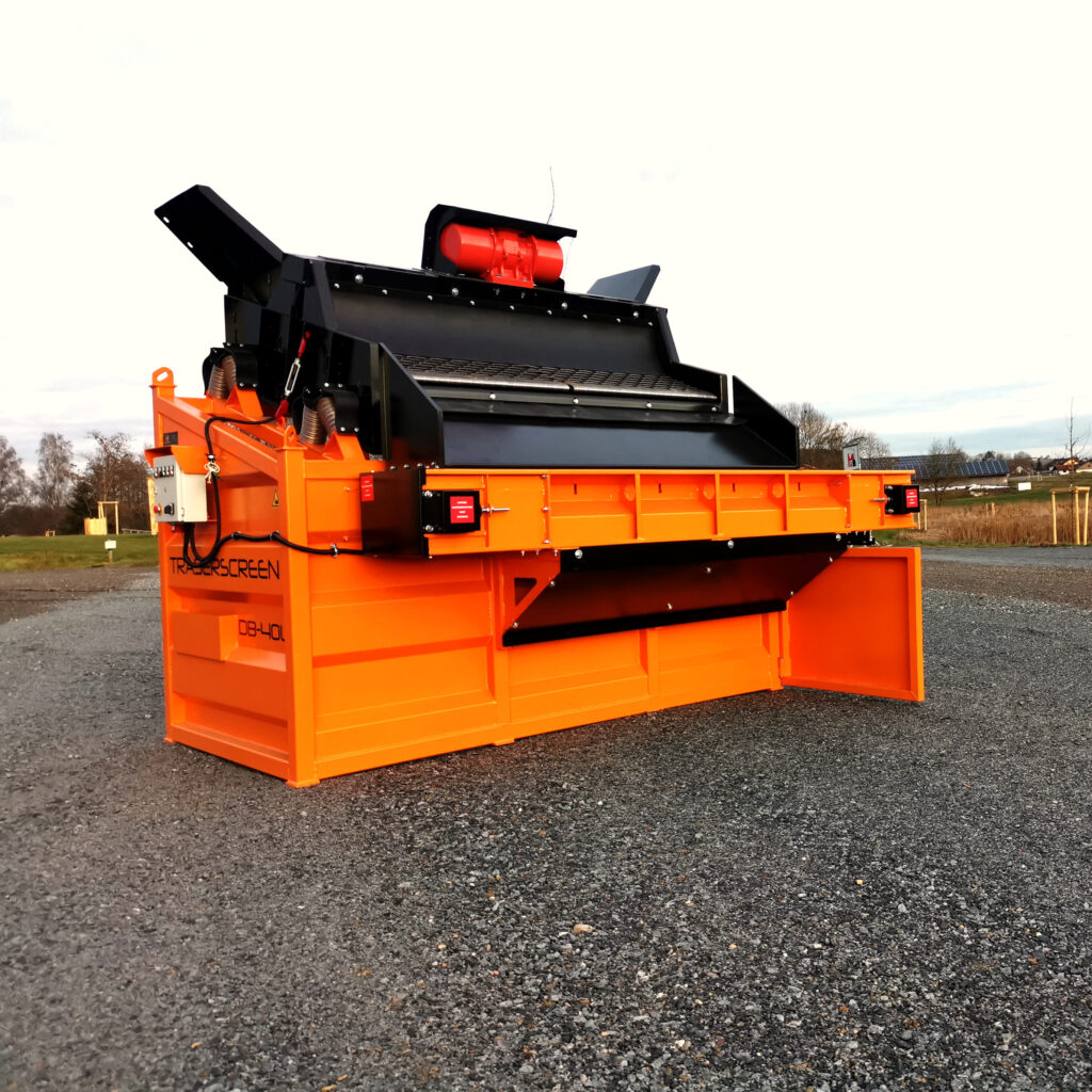 Der orange-schwarze Traserscreen DB-40LC steht auf Schotter und zeigt den großen Siebaufbau mit roten Antriebselementen unter freiem Himmel.
