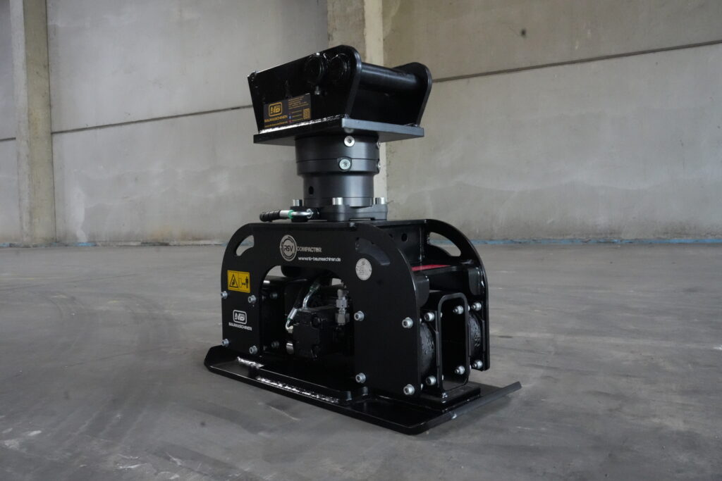 Schwarzer RSV Compactor von NB Baumaschinen in einer Halle, mit massiver Stahlkonstruktion, hydraulischen Anschlüssen und breiter Grundplatte.