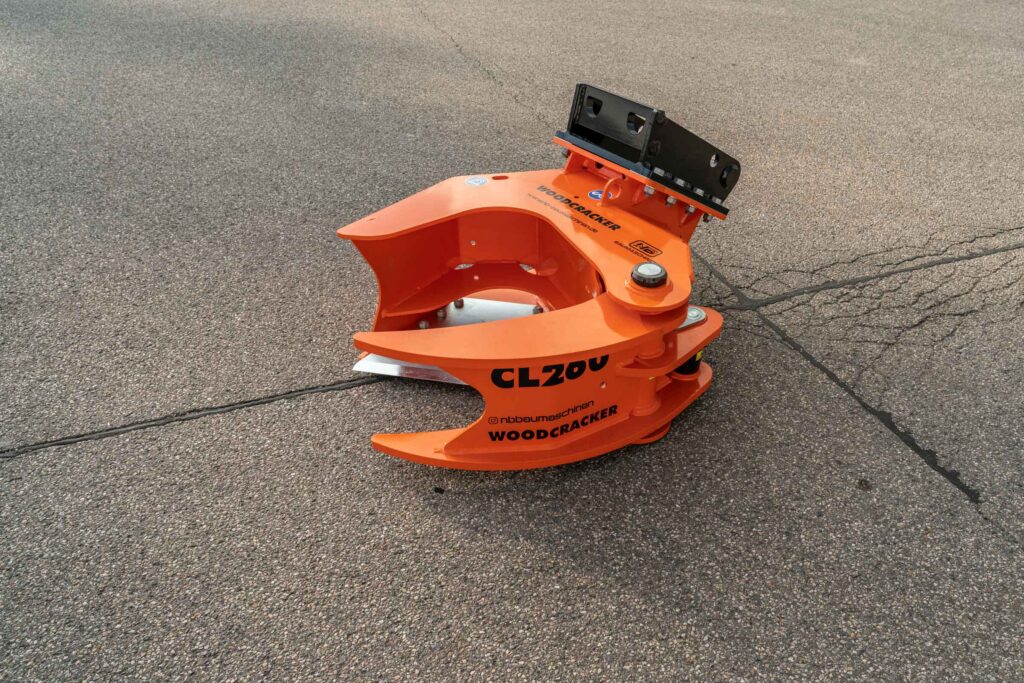 Ein orange-schwarzer WOODCRACKER CL200 mit großem Stahlgehäuse steht auf Asphalt, mit schwarzer Aufnahmeplatte und sichtbaren Markenaufdrucken.
