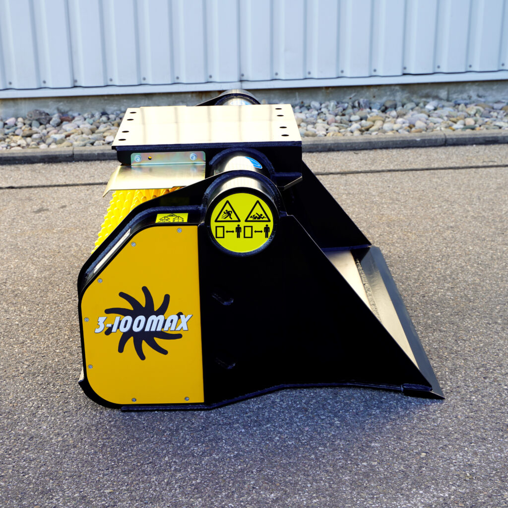 Ein gelb-schwarzer GYRUstar 3-100MAX mit Warnsymbolen und großem Modellschriftzug steht auf Asphalt vor einer hellen Hallenwand.