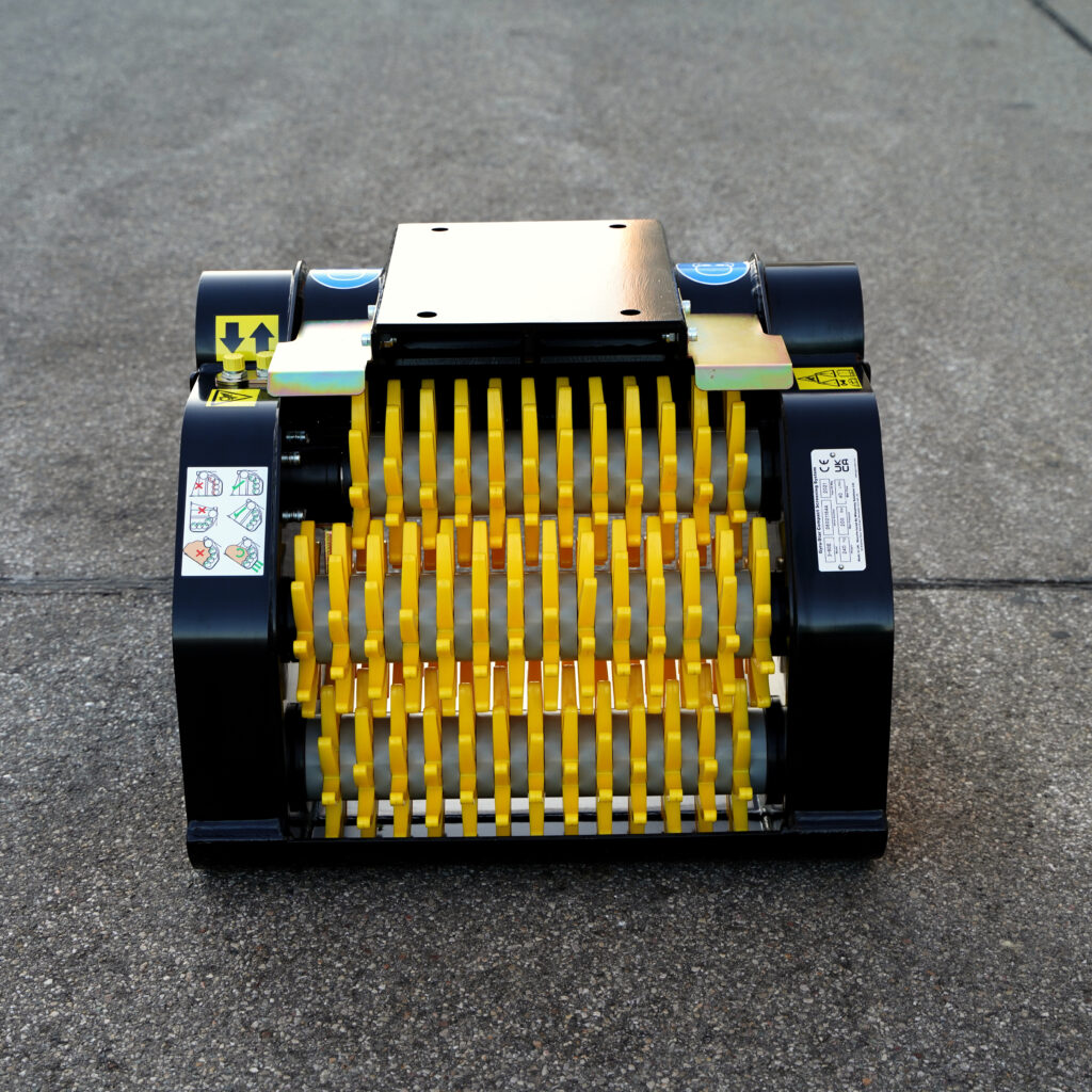 Vor grauem Asphalt steht das kompakte Siebmodul GYRUstar 3-60E-2 mit gelben Rotorleisten, schwarzen Seitenwänden und Warnaufklebern im Frontblick.