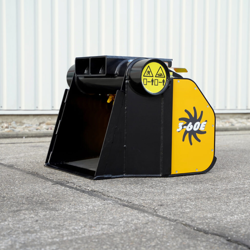 Ein schwarz-gelber GYRUstar 3-60E steht vor einer hellen Hallenwand auf Asphalt, mit offener Schaufel, Warnsymbolen und gut sichtbarer Typenbezeichnung.