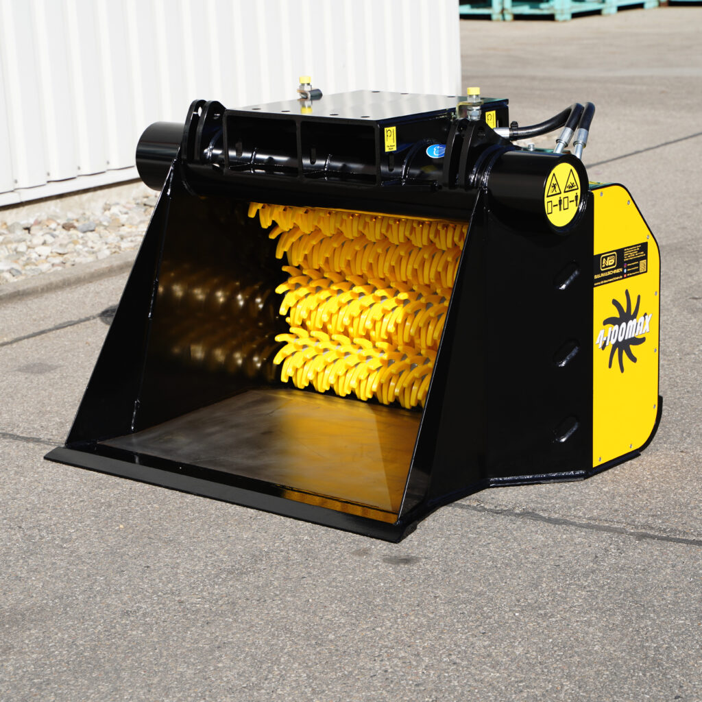 Der schwarze und gelbe GYRUstar 4-100MAX-4 zeigt breite Einlauföffnung, gelbe Schneidwalzen und Hydraulikschläuche auf Asphalt im Freien.
