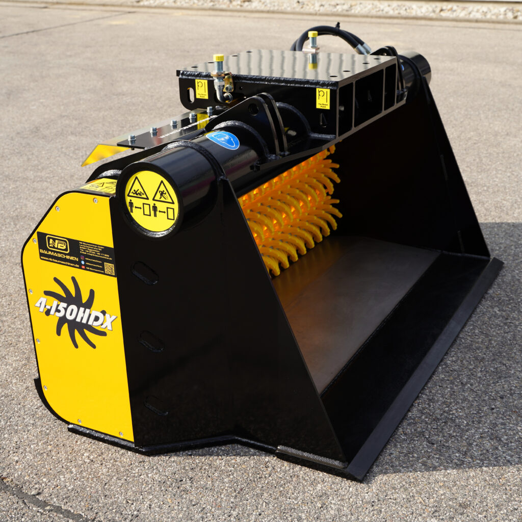 Robuster schwarzer und gelber GYRUstar 4-150HDX mit breiter Metallschaufel, gelben Schutzrollen und Warnhinweisen steht auf Asphalt im Sonnenlicht.