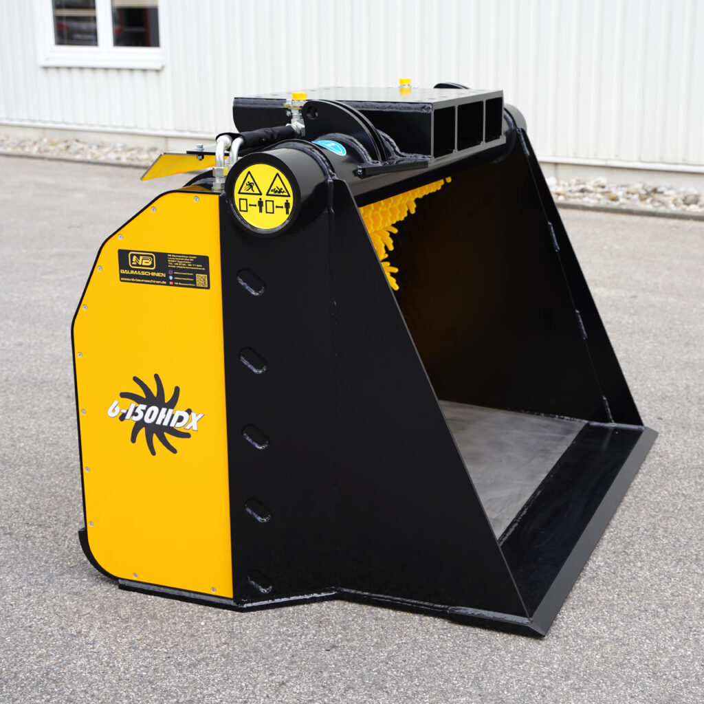 Schwarze und gelbe GYRUstar 6-150HDX-3 Sortiergabel mit Warnsymbolen und Hydraulikanschlüssen steht auf Asphalt vor einer hellen Hallenwand.