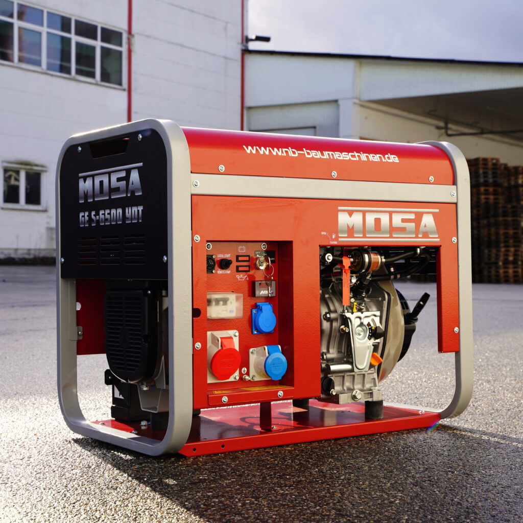 Der rote Mosa GE S-6500 YDT Stromerzeuger steht vor einer Industriehalle, mit sichtbaren Anschlüssen, Motor und silbernem Rahmen auf nassem Asphalt.
