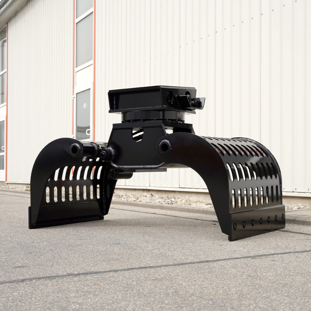 Ein schwarzer Sortiergreifer HG16.20-5 steht vor einer hellen Industriehalle und zeigt breite Schalen mit vielen Schlitzen sowie den massiven Drehkranz.