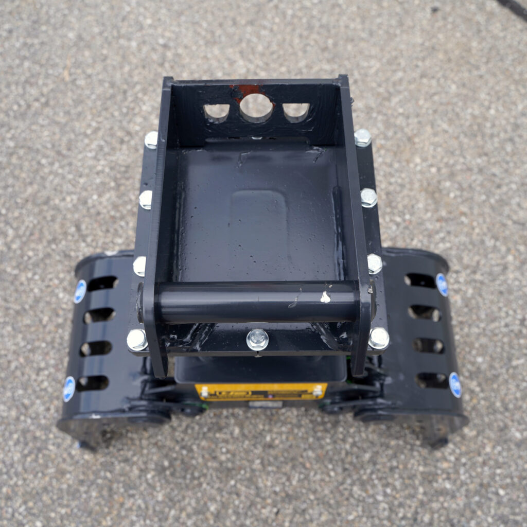 Schwarzer Sortiergreifer PF100-1 aus Metall mit verschraubten Seitenplatten und breitem Aufnahmebereich, von oben auf grauem Asphalt fotografiert.