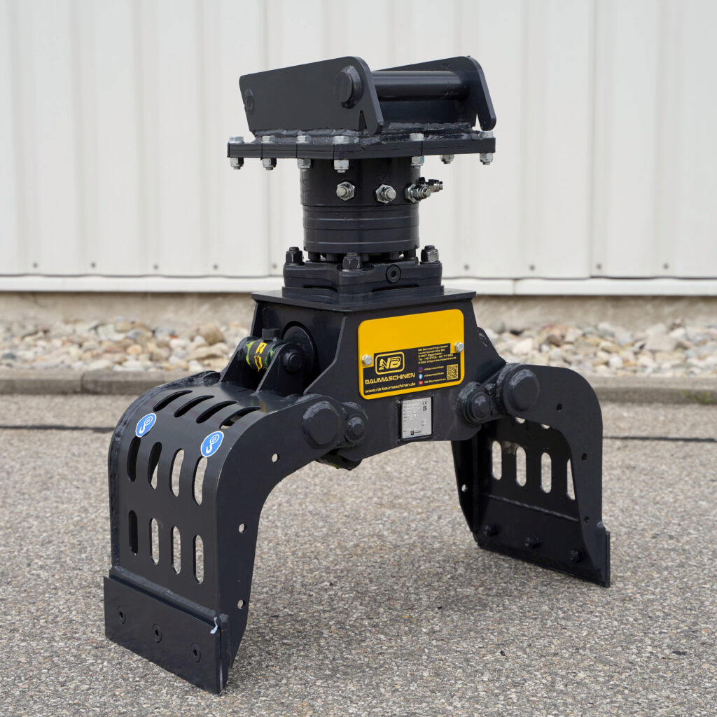 Ein schwarzer Sortiergreifer PF100-5 mit breiten Greifarmen und gelbem NB-Baumaschinen-Schild steht draußen vor einer hellen Wand auf Asphalt.