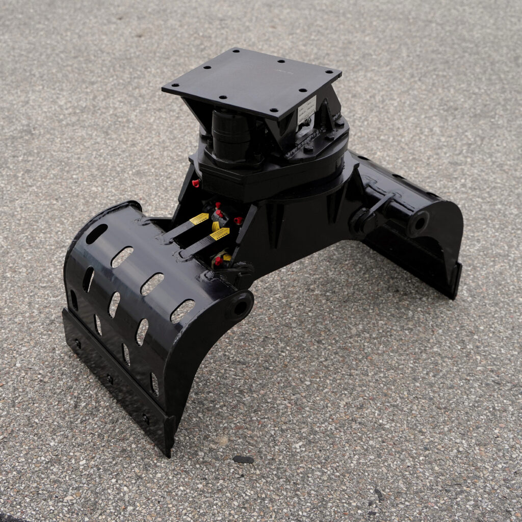 Ein schwarzer Sortiergreifer SG2.3-4 mit breiten Greifarmen, Perforationen und Drehkranz steht auf grauem Asphalt vor neutralem Hintergrund.