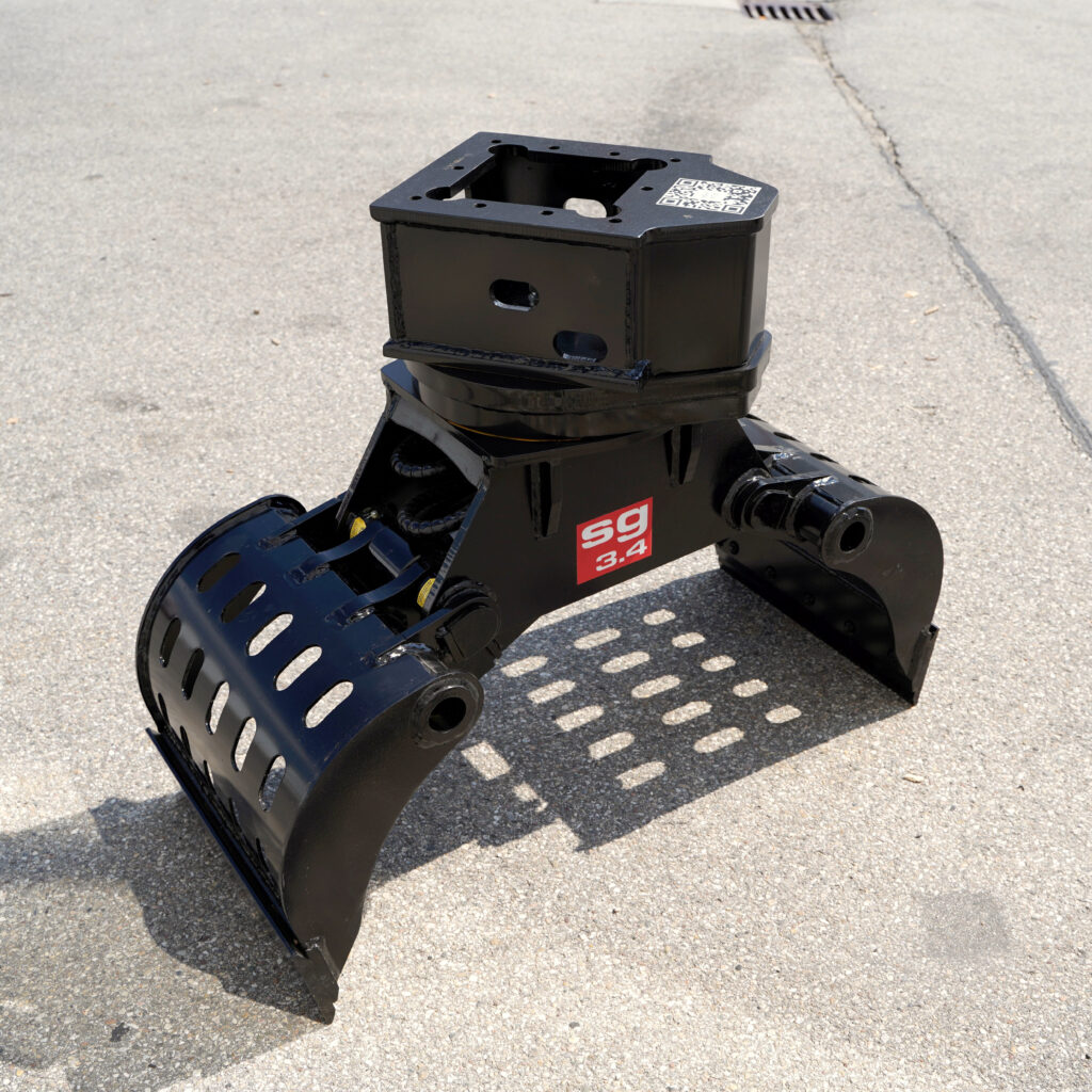 Der schwarze Sortiergreifer SG3.4-5 steht auf Asphalt und zeigt robuste Stahlarme, eine perforierte Greiferschale und einen Anbaukopf mit QR-Code.