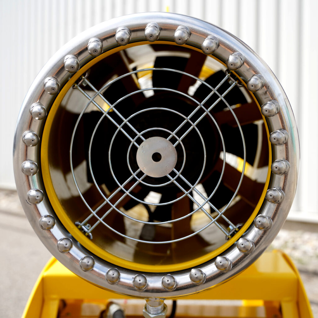 Ein gelb lackierter Demolitor 20 mit runder Metallfront, Schutzgitter und zahlreichen Düsen ist frontal vor einem hellen Industriehintergrund zu sehen.
