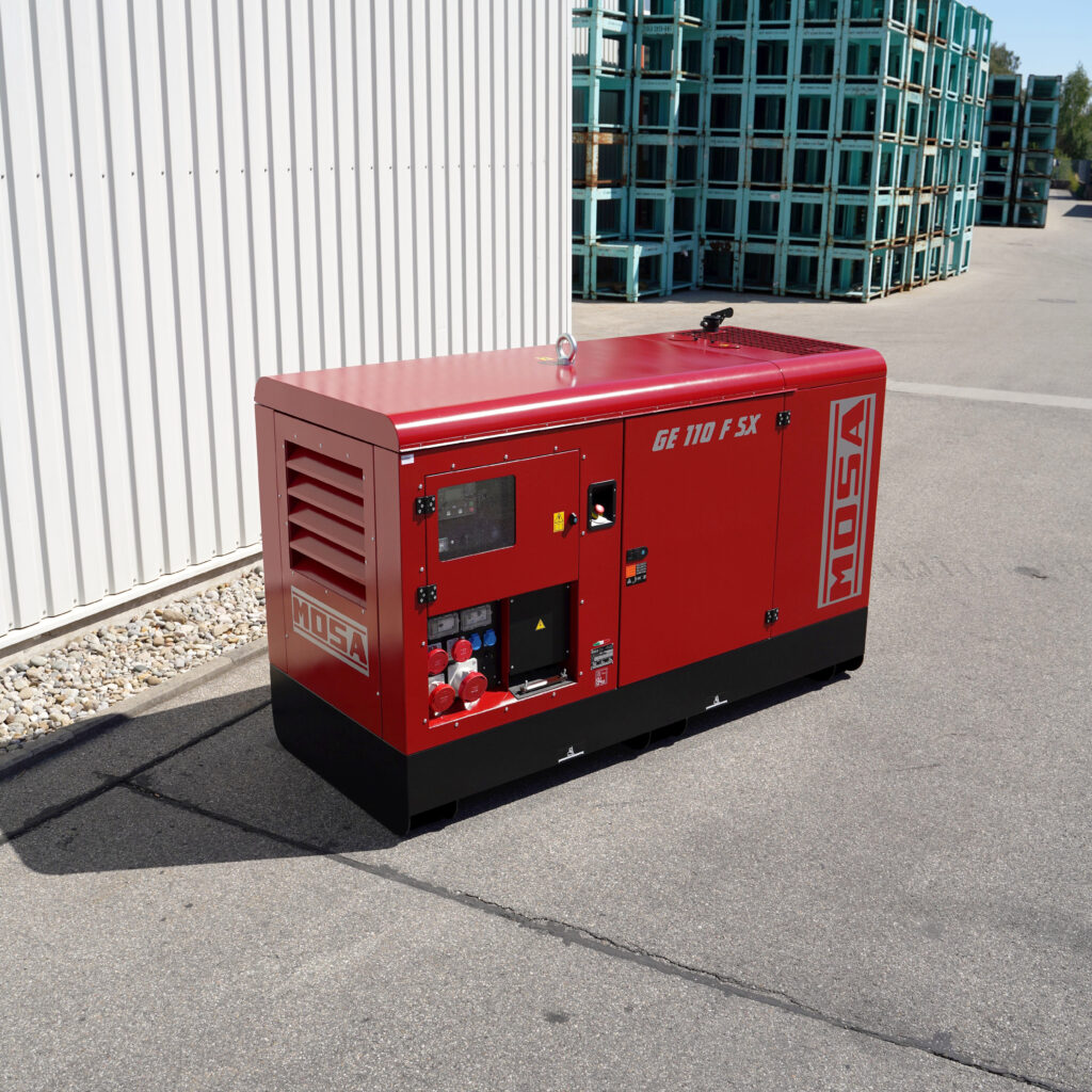 Vor einem hellen Industriegelände steht ein roter Mosa GE 110 F SX Stromerzeuger mit schwarzem Unterbau, Anschlussfeld und markanter Gehäuseform.