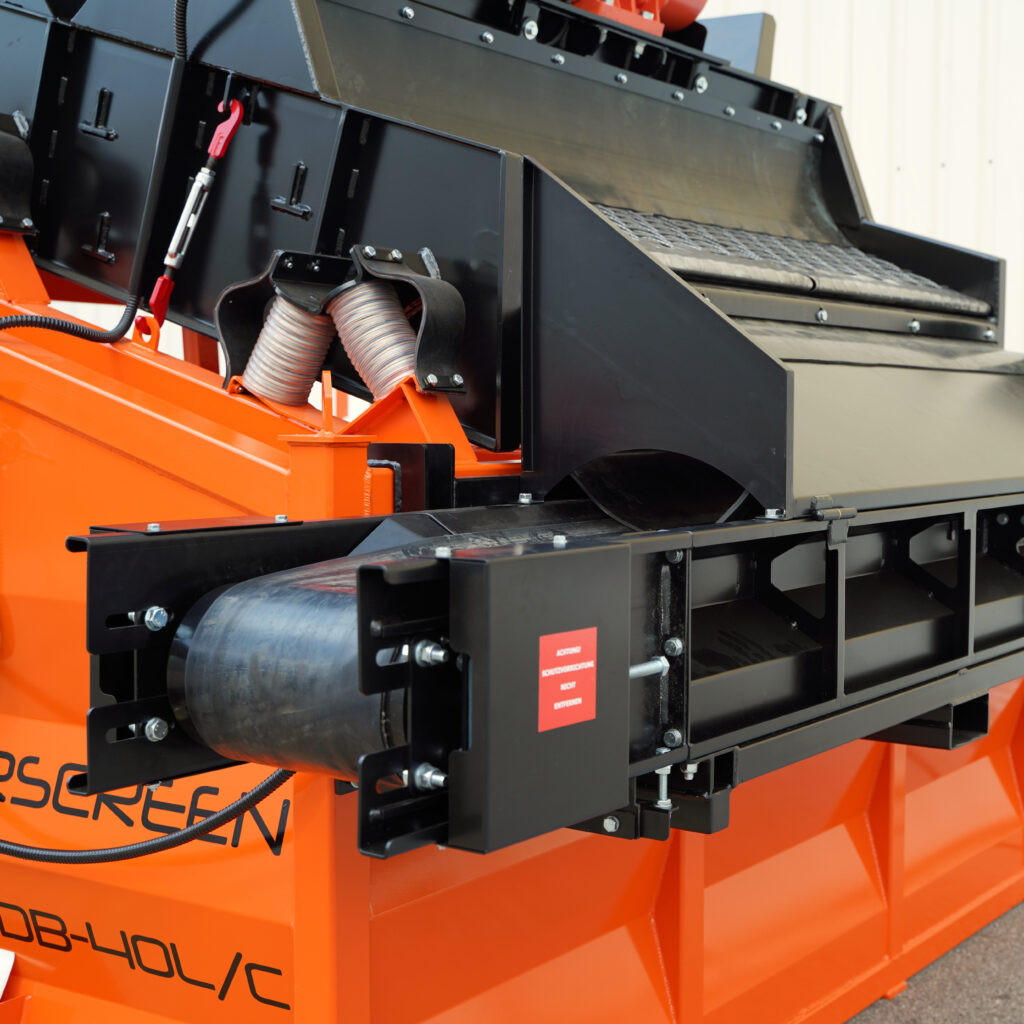 Nahaufnahme einer orange-schwarzen Traserscreen DB-40LC-Recyclingsiebmaschine mit Förderband, sichtbaren Hydraulikschläuchen und stabilem Stahlrahmen.