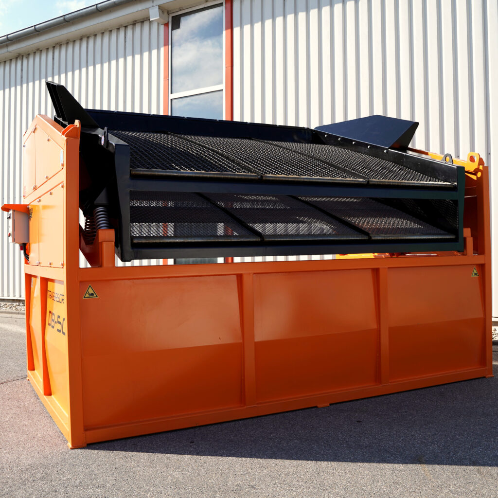 Orange-schwarze Traserscreen DB-50-8 mit geneigtem Siebdeck und Metallgitter vor einer hellen Industriehalle unter blauem Himmel im Freien.