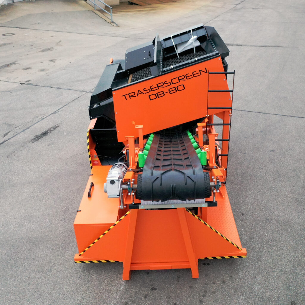 Auf dem Asphalt steht eine orange-schwarze Siebanlage von Traserscreen DB-80 mit Förderband, Gitterflächen und markanter Maschinenverkleidung.